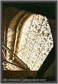 The gilded lattice of a high window of the southern belfry. St. Vitus`Cathedral. Prague